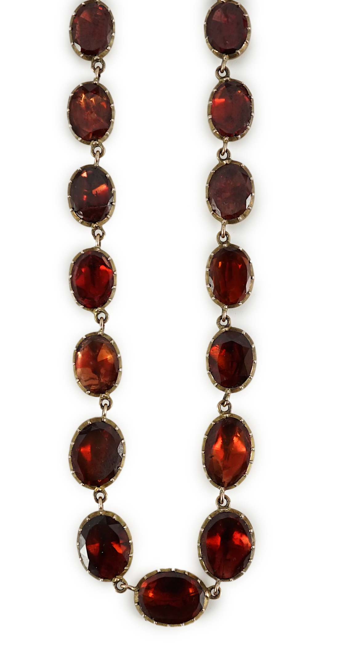 An early 19th century gold mounted graduated foil backed oval cut garnet set choker necklace